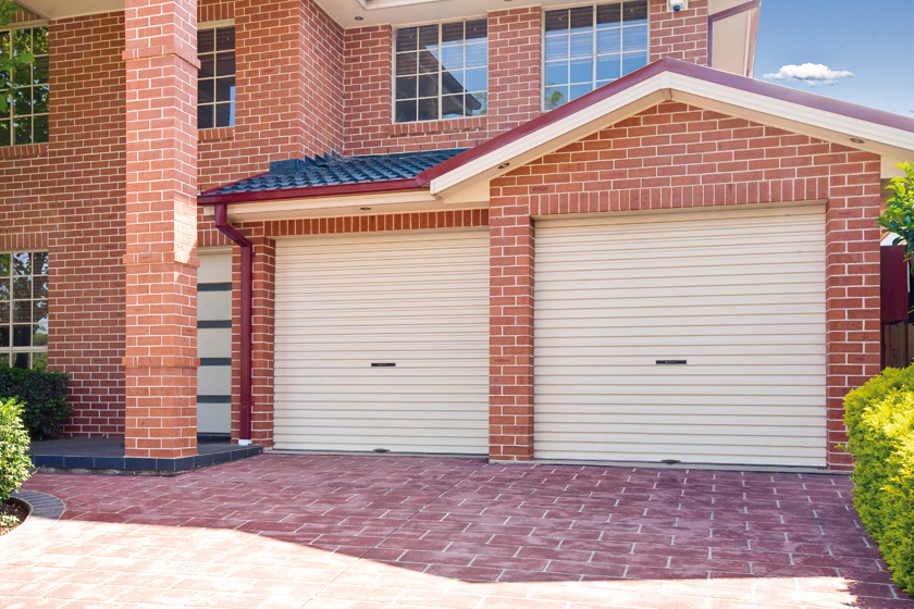 Double garage with closed roller doors and brick exterior, located in Prestons, New South Wales, Australia.