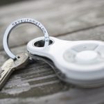 White electronic key automation fob attached to keyring on wooden surface, found in Prestons, New South Wales, Australia.
