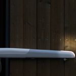 White articulated arm automatic gate opener mounted on a wooden gate, shown at dusk, for homes in Prestons, New South Wales, Australia