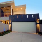 Modern house with closed sectional garage door, evening, in Prestons, New South Wales, Australia.